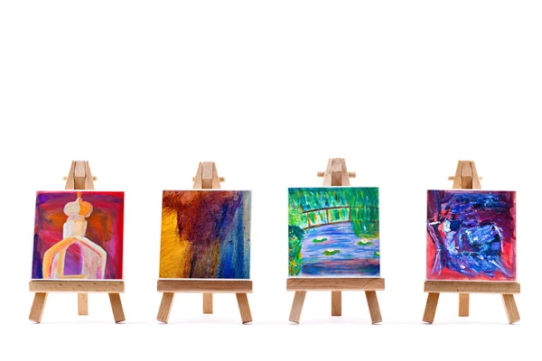 Vier schilderijen op schildersezels geïsoleerd op wit — Stockfoto