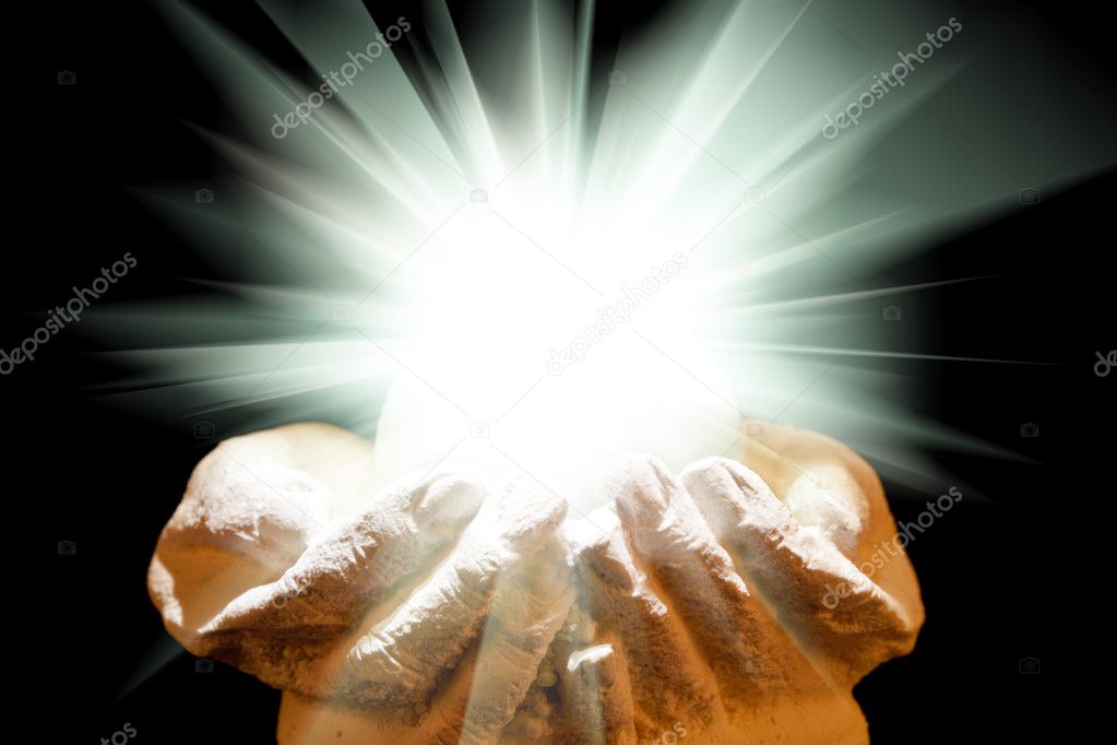 Spiritual light in cupped hands on a black background