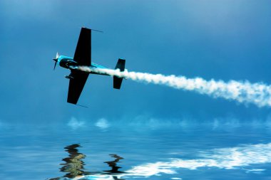 Stunt plane flying close to water clipart