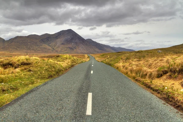 Strada irlandese con vista sulle montagne — Foto Stock