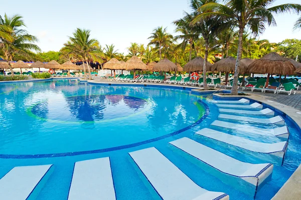Tropisches Schwimmbad mit Sonnenliegen — Stockfoto