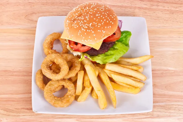 Hamburger z frytkami i krążki cebuli — Zdjęcie stockowe