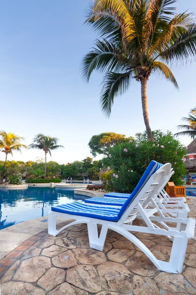 Deckchair at tropical swimming pool — Stock Photo, Image