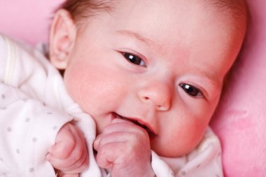 Baby girl lying on a soft blanket and watching clipart