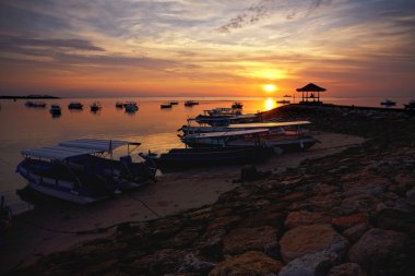 Sunrise over fishing boats on Bali clipart