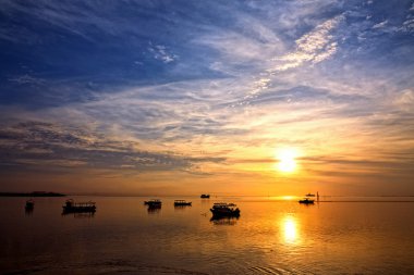 Sunrise over fishing boats on Bali clipart