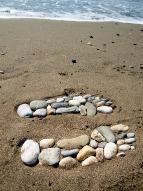 Stone feet in the sand clipart