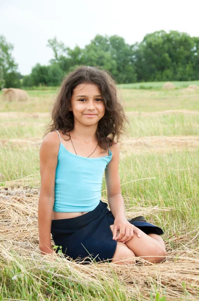 Mooi langharige meisje in een veld — Stockfoto