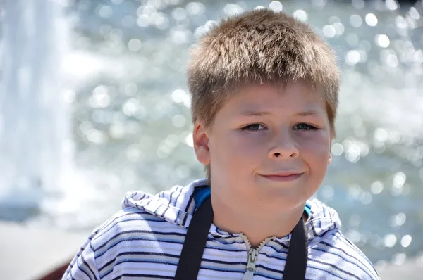 stock image Portrait of a boy on the background of the fountain