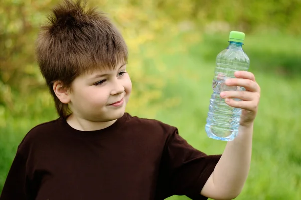 一个男孩与一瓶水的性质 — 图库照片