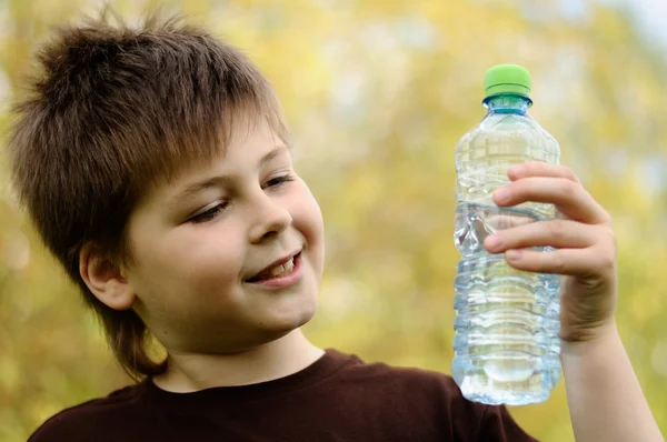 Egy fiú, egy üveg víz a természetben — Stock Fotó