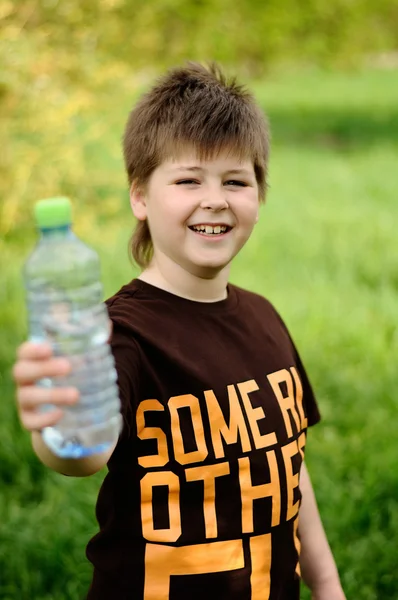 Ένα αγόρι με ένα μπουκάλι του νερού στη φύση — Φωτογραφία Αρχείου