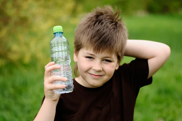 Bir şişe su doğada çocukla — Stok fotoğraf