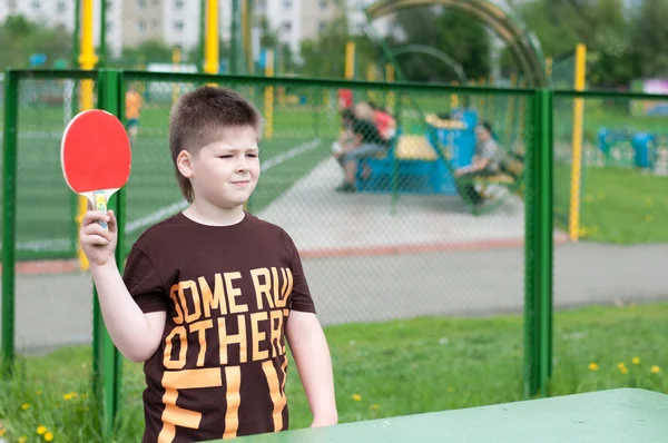 Мальчик играет в настольный теннис — стоковое фото