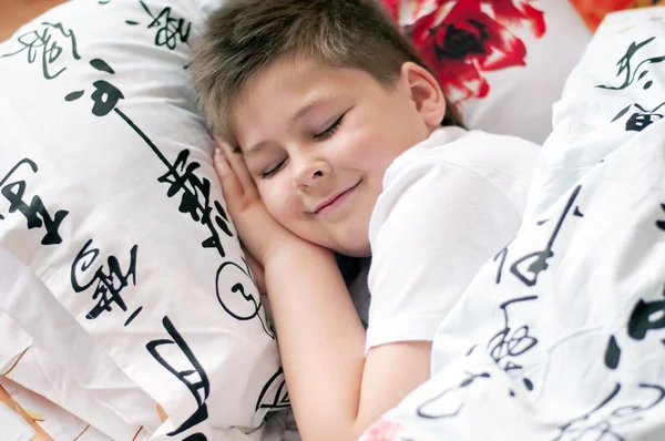 De jongen lag te slapen op een kussen met chinese karakters — Stockfoto