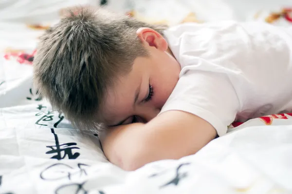 Der Junge schlief auf einem Kissen mit chinesischen Schriftzeichen — Stockfoto