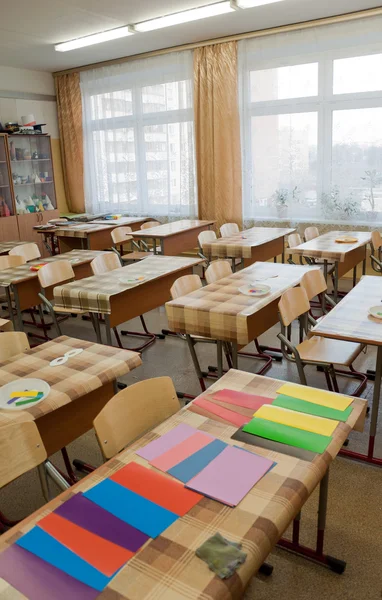 Salle de classe avant la leçon, les bureaux sont recouverts de toile huilée — Photo
