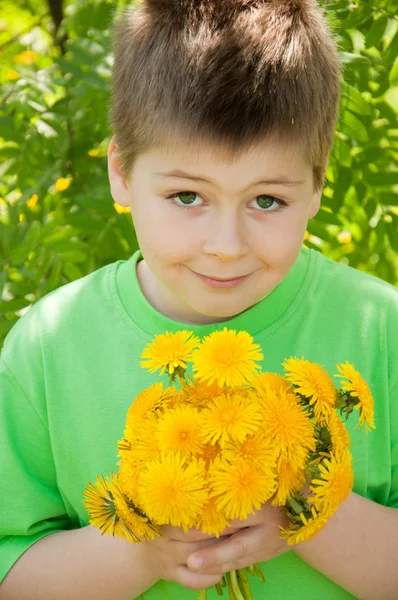 Boy with a bouquet of dandelions — Stock Photo, Image