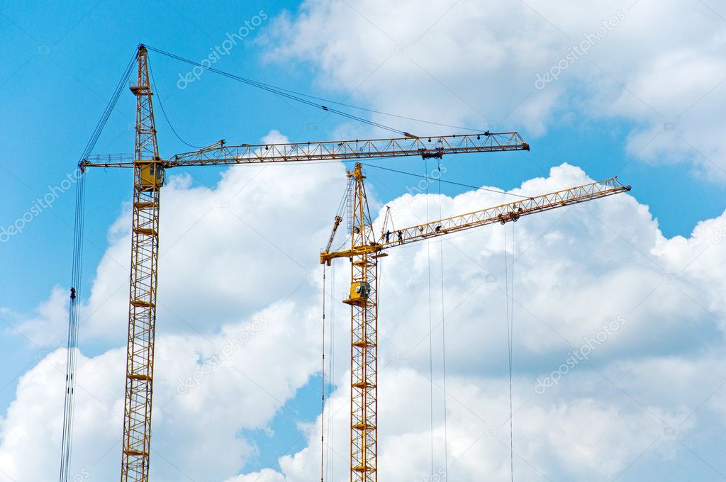 Two cranes on blue sky background