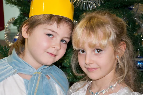 Boy and girl in carnival costumes for Christmas trees — Stock Photo, Image