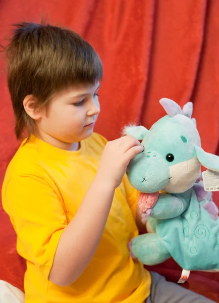Мальчик с мягким игрушечным драконом - символ нового года — стоковое фото