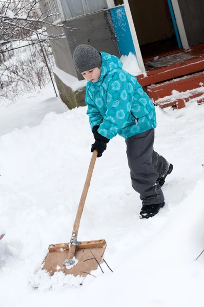 Pojken tar bort snö runt huset — Stockfoto