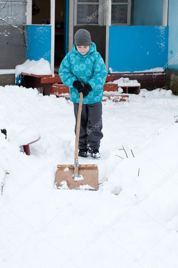 Boy removes snow around the House