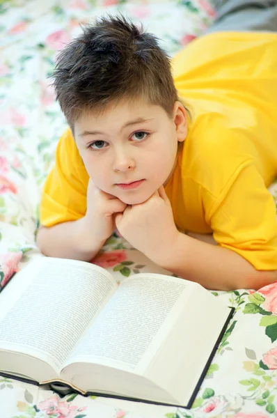 Chłopiec czyta książkę w łóżku — Zdjęcie stockowe
