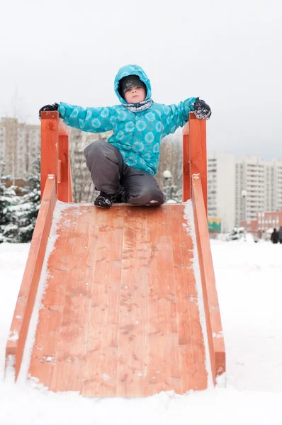 O menino está montando colinas de madeira no inverno — Fotografia de Stock