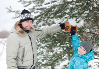 Dad, son and feeding for birds in winter clipart