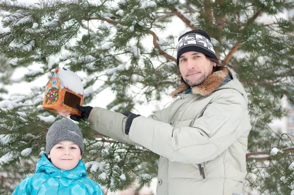 Pappa, son och utfodring för fåglar på vintern — Stockfoto