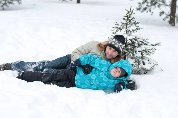 Vater und Sohn ruhen sich im Park im Schnee aus — Stockfoto