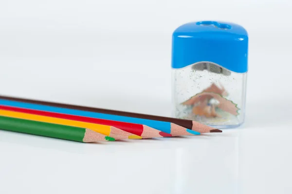 Lápices y sacapuntas de colores sobre un fondo gris — Foto de Stock