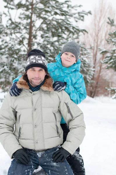 Папа и сын гуляют в зимнем парке — стоковое фото