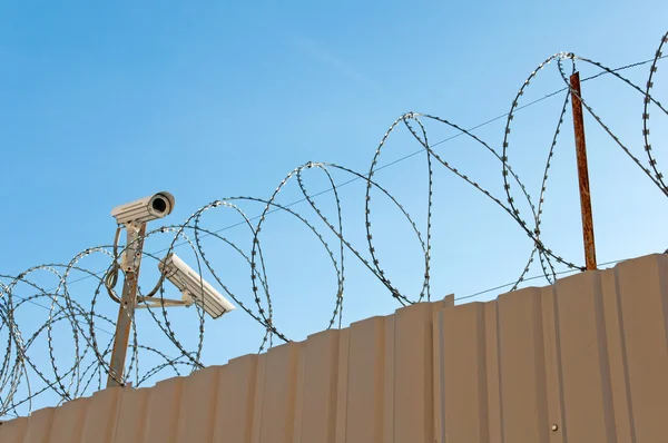 Stock image Camera surveillance and barbed wire