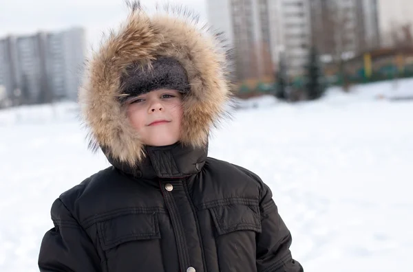Retrato de um menino em uma jaqueta com pele — Fotografia de Stock