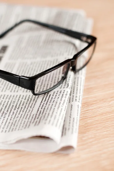 Brýle ležící kolem noviny — Stock fotografie