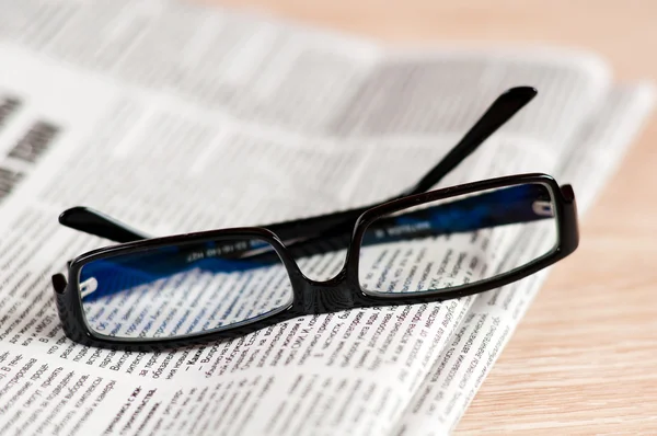 stock image Eyeglasses lying around newspapers