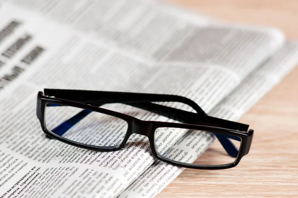 stock image Eyeglasses lying around newspapers