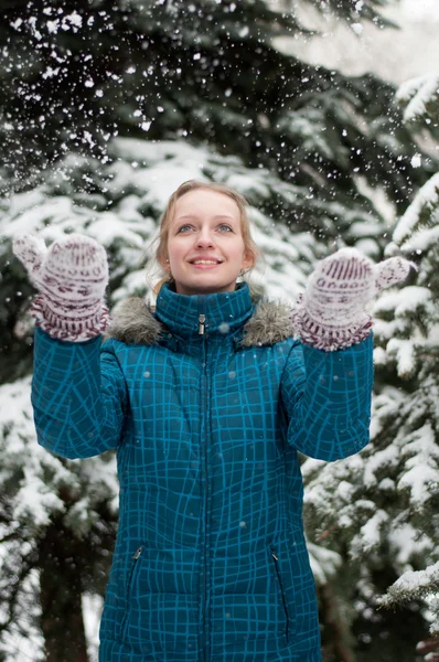 Ein Mädchen in einem Kiefernwald während eines Schneefalls — Stockfoto