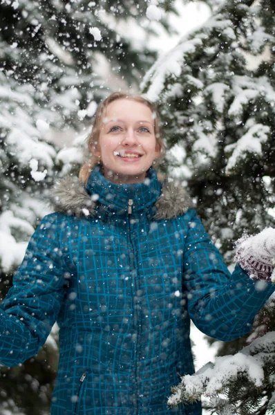 En flicka i en tallskog under ett snöfall — Stockfoto