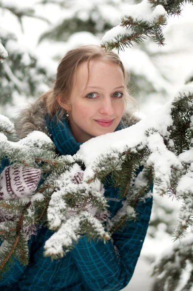 Jovem mulher na floresta de abetos coberta de neve — Fotografia de Stock