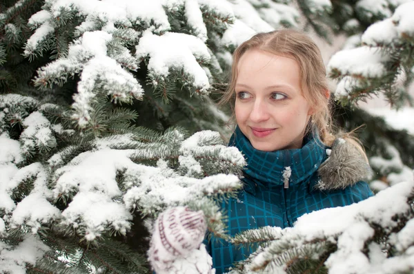 Junge Frau im schneebedeckten Fichtenwald — Stockfoto