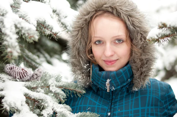 Jovem mulher na floresta de abetos coberta de neve — Fotografia de Stock