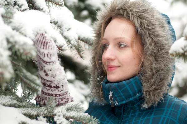 Mladá žena v sněhem pokryté smrkovým porostem — Stock fotografie