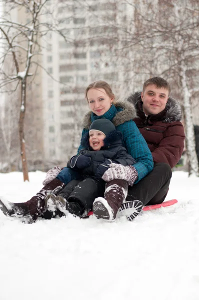 Junge Familie fährt mit Schlitten in die Hügel — Stockfoto