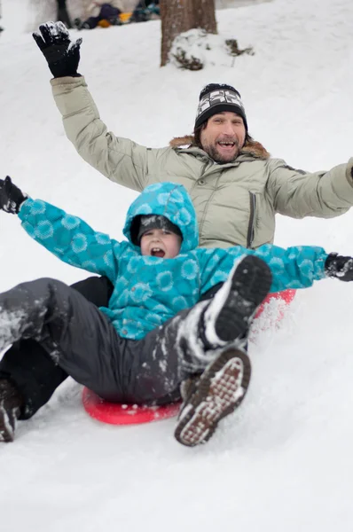Pai e filho montando uma colina congelada — Fotografia de Stock