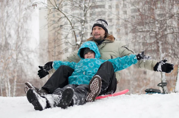 Papa en zoon rijden op een bevroren heuvel — Stockfoto