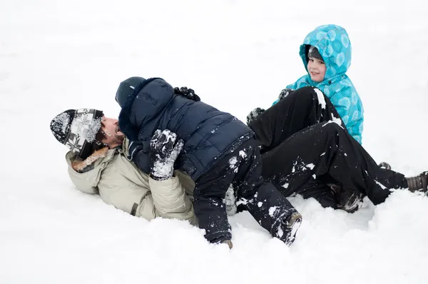 Папа с детьми играет в снегу — стоковое фото