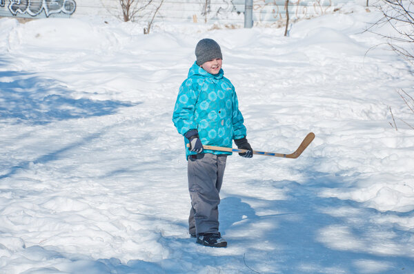 A boy playing hockey in the snow